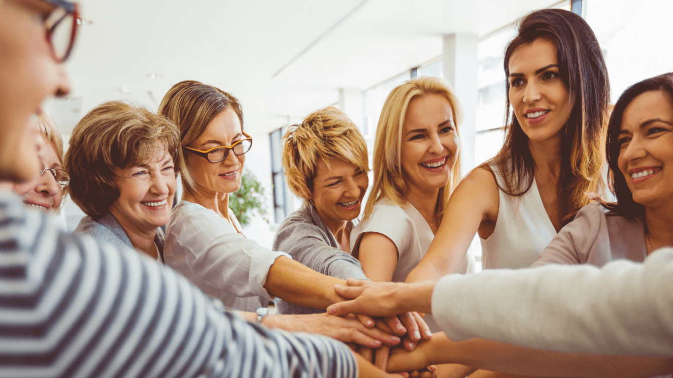 A group of women of different ages together, hands joined